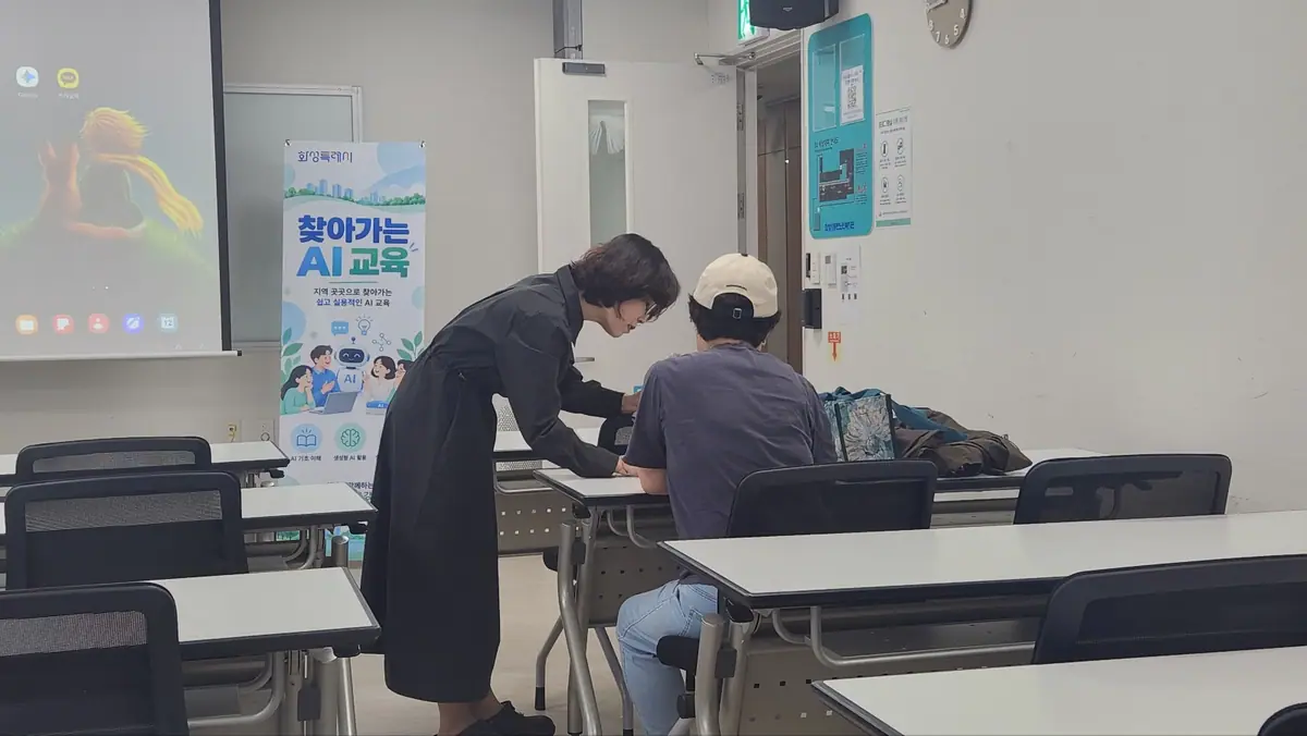 화성시동탄노인복지관 찾아가는 AI 교육에서 강사가 노인 수강생 곁에서 스마트폰 사용을 1:1로 돕는 모습