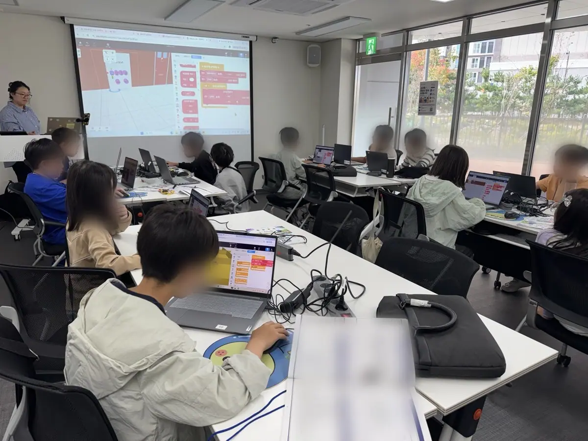 AI 소셜 리빙랩 공유학교 수업에서 초등학생들이 노트북으로 블록 코딩을 실습하는 모습